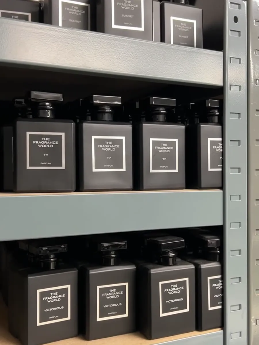 Rows of black bottles, each shelf labelled with its scent